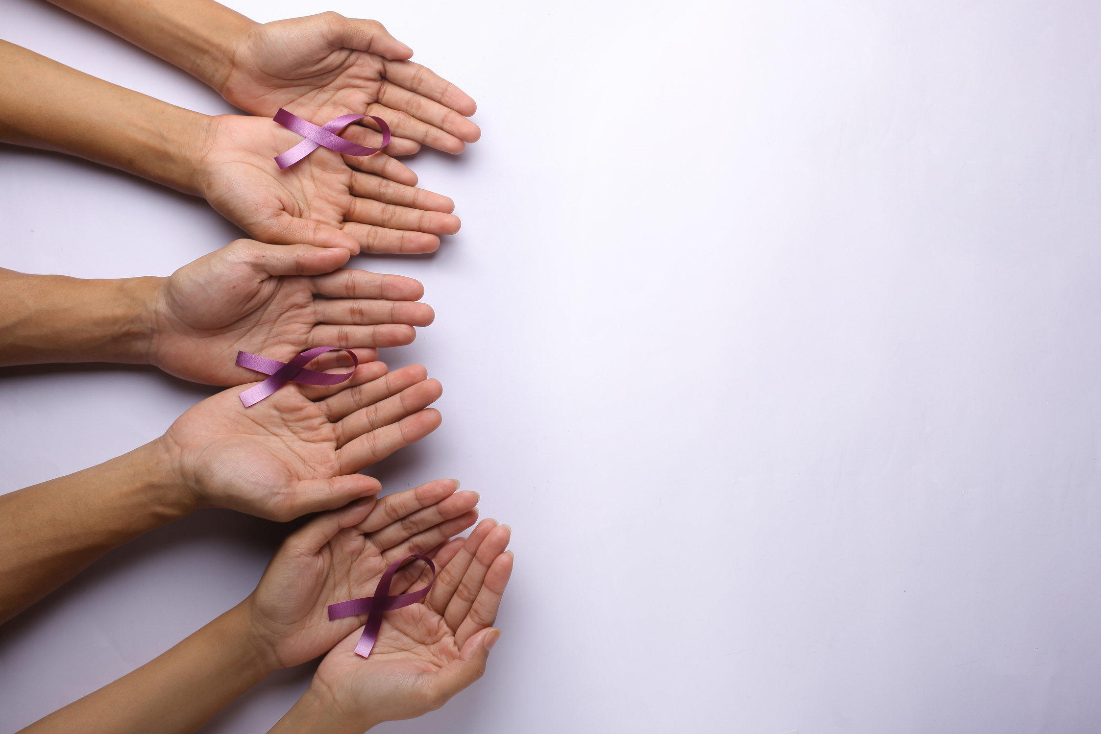 Purple ribbons on people's hands for cancer awareness